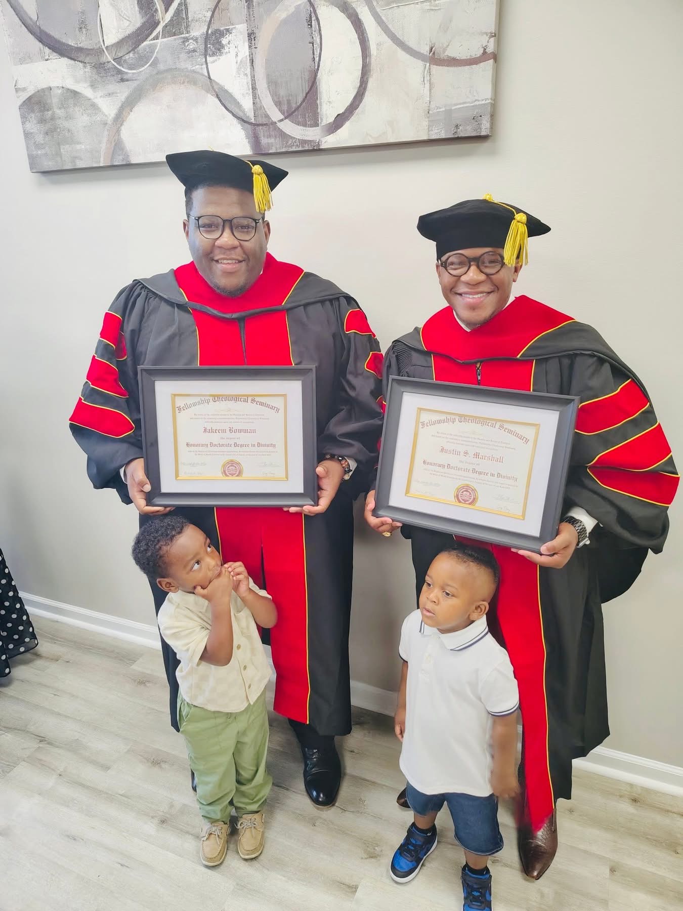 Dr. Jakeem Bowman and Dr. Justin S. Marshall holding their honorary doctorate diplomas